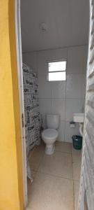 ein Bad mit einem weißen WC und einem Fenster in der Unterkunft Yellow House Itapuama in Cabo de Santo Agostinho