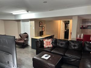 a living room with a leather couch and chairs at Blissful 2Bedroom Cozy Lowerlevel Unit PrivateEntrance in Gatineau