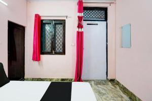 Una habitación con cortinas rojas y una puerta. en Hotel O Gautam, en Haridwar 21 fotos más