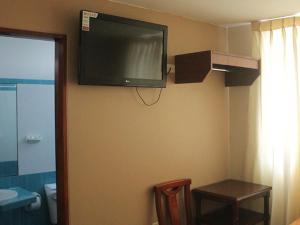 トルヒーリョにあるHotel Jorge Chavezのホテルの部屋の壁に薄型テレビが付いています。