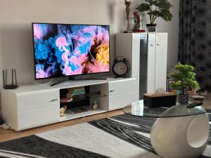 a living room with a tv on a white entertainment center at Zara’s Home Apartaments in Petroşani
