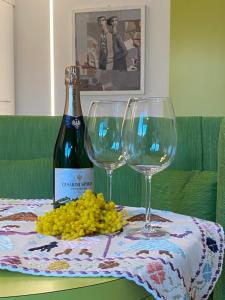 a bottle of wine and two wine glasses on a table at Halloggio98 in Rivalta