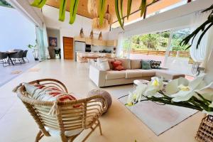 een grote woonkamer met een bank en stoelen bij Villa My Zen 4Br Private Pool & Walk to Beach in Chaweng Noi Beach