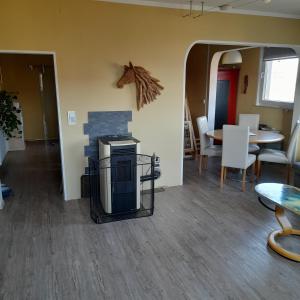 una stanza con camino, tavolo e sedie di Ferienwohnung Rhönblick a Bad Königshofen im Grabfeld