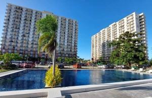 palma przed dwoma wysokimi budynkami w obiekcie Z Luxe Studio w Cebu