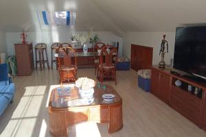 a living room with a tv and a table and chairs at Area da Barca Atico in Samieira