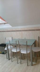 a green table and chairs in a room at Area da Barca Atico in Samieira