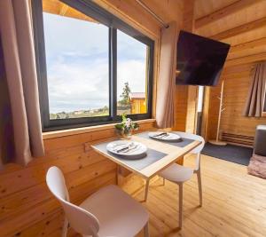 a dining room with a table and chairs and a large window at Casinha Melissa in São Roque do Pico
