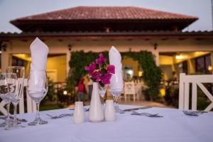 een tafel met wijnglazen en bloemen erop bij Los Flamencos Aparthotel Beach Club in Bayahibe