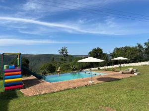 a swimming pool with a slide and a playground at The Windmill Country Retreat in Hazyview