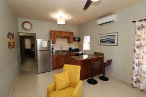 a kitchen with a yellow chair and a refrigerator at SYL Apartment - Modern, Car Rental Available in North Side