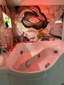 a pink sink in a bathroom with a painting on the wall at Suite Sanità in Naples