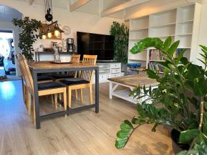 a dining room with a table and chairs and a tv at Cozy guesthouse with perfect location in Malmö