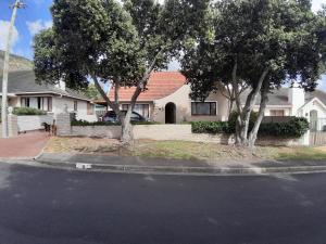 a house with two trees on the side of a street at The Pool Cottage in Fish Hoek