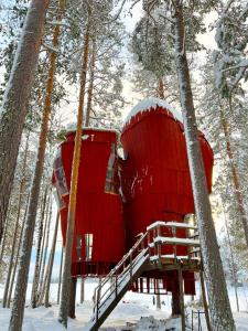 a red tree house in the woods in the snow at Haven Islands incredible treehouse on private island in Torrflonäs +70 photos