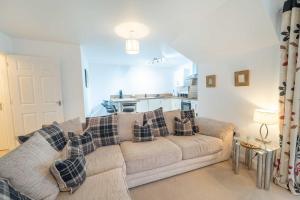 Una sala de estar con un sofá y una cocina. en Druimarbin Falls, en Fort William