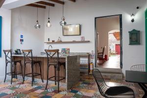 a kitchen with a bar with chairs and a mirror at La Casa de Isa in Cali