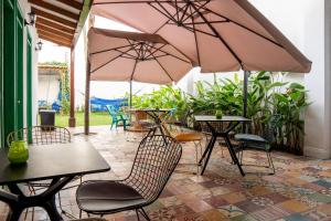 a patio with tables and chairs and umbrellas at La Casa de Isa in Cali
