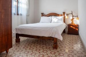 a bedroom with a bed with white sheets and pillows at La Casa de Isa in Cali