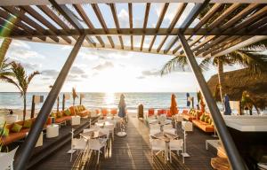 a restaurant on the beach with chairs and tables at The Carmen Hotel - Ocean Front in Playa del Carmen