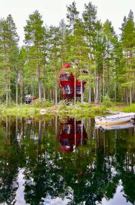 a red tent in the woods next to a lake at Haven Islands incredible treehouse on private island in Torrflonäs