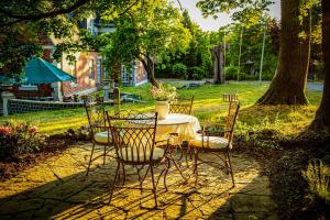 a table with chairs and a vase on it at Herrenhaus Brookhusen nahe Rostock & Ostsee in Benitz