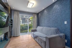 a living room with a couch and a blue wall at Loft One no Centro by Achei Gramado in Gramado