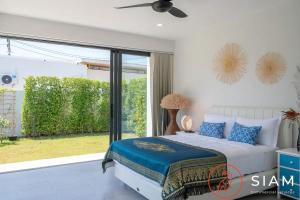 a bedroom with a bed and a sliding glass door at Villa Awaken 3br Private Pool in Bang Rak Beach +25 photos