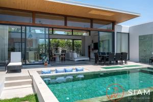 a house with a swimming pool and a patio at Villa Awaken 3br Private Pool in Bang Rak Beach