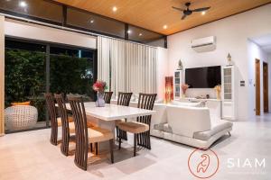 a dining room with a table and chairs at Villa Awaken 3br Private Pool in Bang Rak Beach