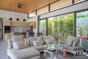 a living room with a couch and a glass table at Villa Awaken 3br Private Pool in Bang Rak Beach