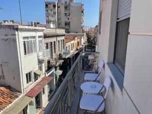 Un balcón con sillas y una mesa en un edificio. en Voupalou Apartments 2, en Chios