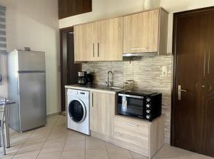 cocina con microondas, lavadora y nevera en Voupalou Apartments 2, en Chios 1 foto más