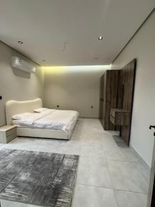 a bedroom with a bed and a table in it at شقه مفروشة ببطحاء قريش in An Nikāshah +24 photos