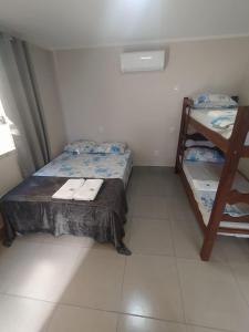 a small room with a bed and bunk beds at Flat Familiar em Capitolio Charlene Paiva in Capitólio