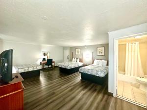 a hotel room with two beds and a television at Red Carpet Inn - Stamford in Stamford +53 photos