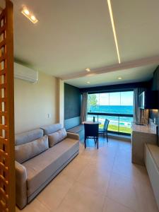 a living room with a couch and a table at Flat beira mar em Tamandaré Carneiros - Kauai in Tamandaré