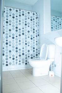 a bathroom with a toilet and a shower curtain at Spacious & Serene 3-Bedroom Condo at Kai Villa in Accra