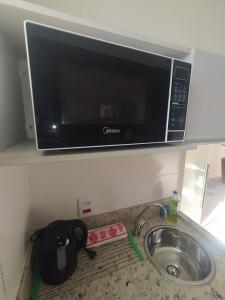 a microwave oven above a sink in a kitchen at Flat Familiar em Capitolio Charlene Paiva in Capitólio +10 photos