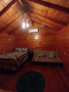 a bedroom with two beds in a wooden cabin at Chalet del lago Don Asterio in Ciudad del Este