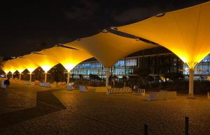 a row of yellow umbrellas in front of a building at night at Charming Sailboat in Lisbon