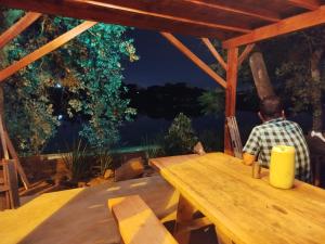 a man sitting at a table with a view of the water at Chalet del lago Don Asterio in Ciudad del Este