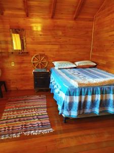 a bedroom with a bed and a wooden wall at Chalet del lago Don Asterio in Ciudad del Este