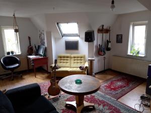 a living room with a table and guitars in it at Roof-Top View Over Möllevångstorget in Malmö