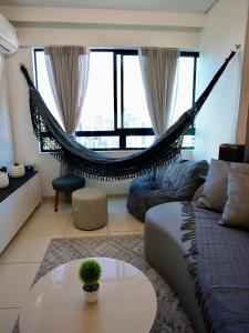a living room with a hammock and a couch at Apartamento de luxo em Candeias BEACH in Recife +50 photos