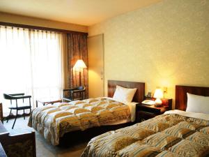 A bed or beds in a room at Hotel Grace Hakuba