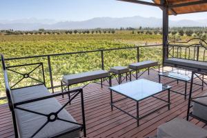 une terrasse avec des chaises et des tables et une vue sur un champ dans l'établissement Casa entre viñedo con vista a la Cordillera, à Las Compuertas