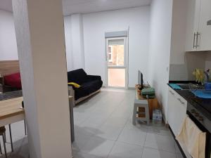 a kitchen and a living room with a couch in it at Finisterrae Centro in Finisterre