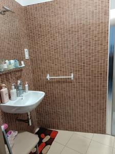 a bathroom with a sink and a tiled wall at Finisterrae Centro in Finisterre