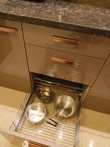 two metal bowls in an oven under a counter at Taj Serenity Divine Luxe Retreat in Chhatikara